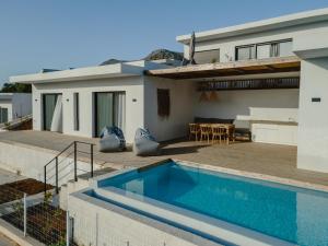 a house with a swimming pool in front of a house at Villa Ilios in Paleros