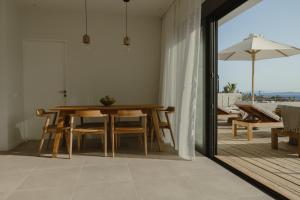 a dining room with a table and an umbrella at Villa Ilios in Paleros