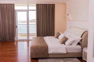 a bedroom with a bed with a view of the ocean at Rafaelo Deluxe Hotel & Spa Shengjin in Shëngjin +19 photos