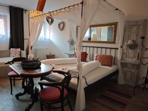 a living room with a canopy bed and a table at Penzion U Švarců in Zduchovice +62 photos