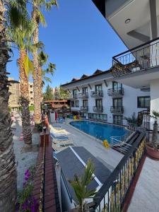 a hotel with a swimming pool and palm trees at Orange Garden Aparts & Hotel THE NORDIC in Kemer