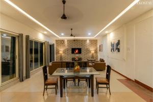 a dining room with a table and chairs and a couch at Ekostay - Crown Villa in Alibaug