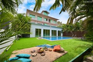 a house with a yard with a swimming pool at Ekostay - Crown Villa in Alibaug