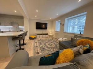 a living room with a gray couch and a kitchen at 1 The Maltings, Crail in Crail
