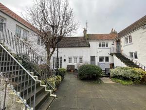 a group of white houses with stairs in a yard at 1 The Maltings, Crail in Crail