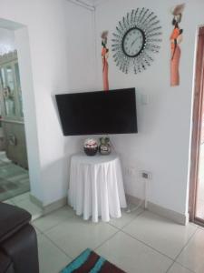 a room with a table and a clock on the wall at THE ROSE BnB in Soweto +18 photos