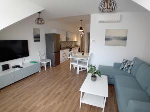 a living room with a blue couch and a kitchen at Berki Apartman in Körmend +23 photos