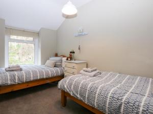 a bedroom with two beds and a window at 3 Bay View Terrace in Llandudno