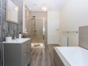 a bathroom with a sink and a shower at 3 Bay View Terrace in Llandudno +16 photos