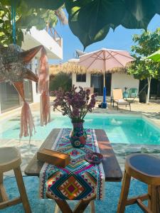 a table with a vase of flowers next to a pool at Private Beach House in AguaBlanca Peaceful Getaway in Playa Agua Blanca