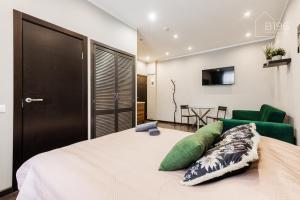 a bedroom with a bed and a green chair at ApartHotel Riga Self Registration & Check-in in Riga