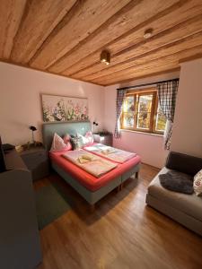 a bedroom with a bed and a couch at Chalet - Appartementhaus Alma in Haus im Ennstal