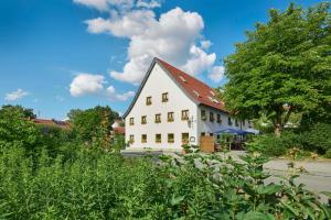 a large white house with a red roof at Gasthaus Alter Wirt in Oberneuching
