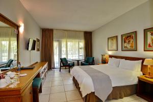 a hotel room with a bed and a table and chairs at Pilanesberg Hotel in Boshoek