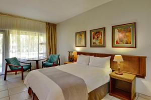 a hotel room with a bed and a table and chairs at Pilanesberg Hotel in Boshoek