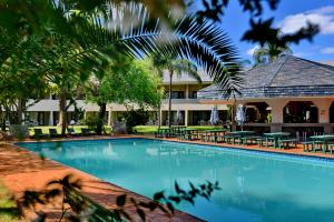a swimming pool in front of a resort at Pilanesberg Hotel in Boshoek