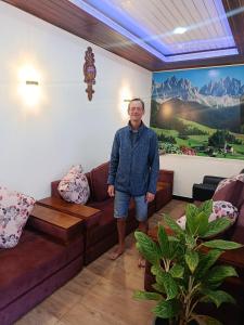 a man standing in a living room with a couch at Horizon Guest Hatton in Hatton