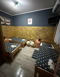 two beds in a room with blue walls at Vila Alexandra 2025 in Bačka Topola