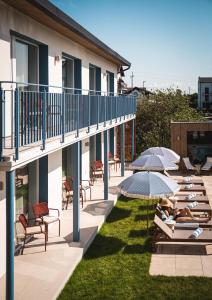 a hotel patio with lounge chairs and umbrellas at Złota 34 Karwia in Karwia