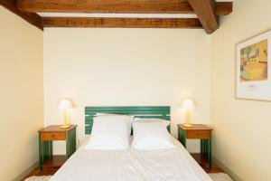 a bedroom with a bed with two lamps on tables at Le Logis d Orgeval in Orgeval