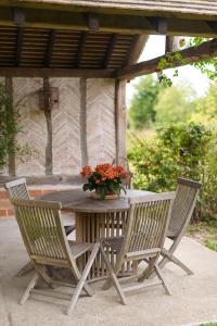 a table with two chairs and a vase of flowers at Le Logis d Orgeval in Orgeval