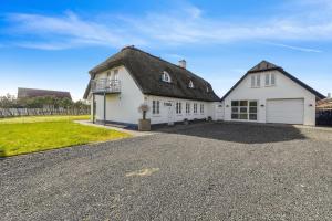 a house with a thatched roof and a driveway at Holstvej 21 Holiday Home For 12 Guests With An Extra Bonus in Blokhus