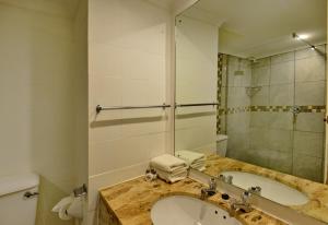 a bathroom with a sink and a mirror at Pilanesberg Hotel in Boshoek