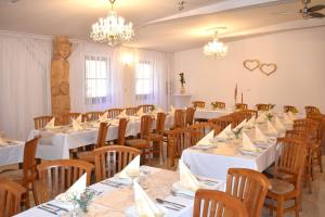 a banquet room with white tables and wooden chairs at Penzión Mlynárka in Rajecké Teplice