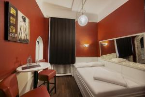 a room with a couch and a table and a sink at Hotel Goldene Spinne in Vienna