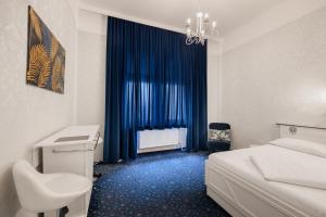 a bedroom with a bed and a desk and a window at Hotel Goldene Spinne in Vienna +4 photos
