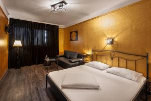 a hotel room with a bed and a chair at Hotel Goldene Spinne in Vienna