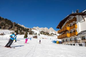 a group of people skiing on a ski slope at Hotel San Marco in Passo San Pellegrino