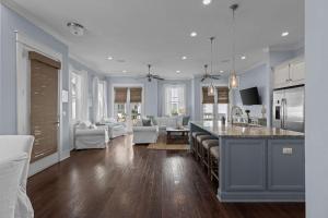 a large kitchen and living room with a counter top at Prominence 30A - Coastal Cottage in Panama City Beach