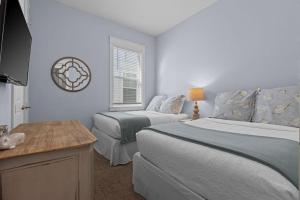 a bedroom with two beds and a table and a window at Prominence 30A - Coastal Cottage in Panama City Beach +48 photos