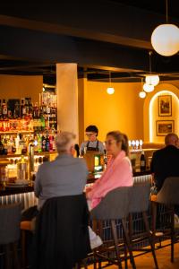 a group of people sitting at a bar at The Village Hotel Douglas in Cork