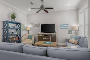 a living room with a blue couch and a tv at Sea Haven At Prominence in Watersound Beach
