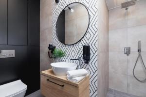 a bathroom with a sink and a mirror at Apartamenty EN Zator in Podolsze +21 photos