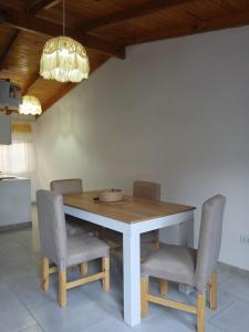 a dining room table with chairs and a light fixture at merlomar1 in Merlo