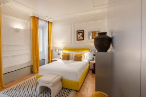 a bedroom with a white bed and yellow curtains at The Couper Umiltà in Rome