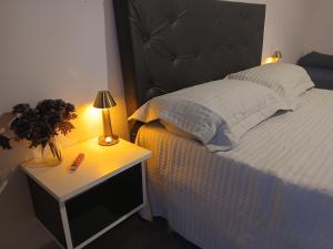 a bedroom with a bed and a nightstand with a lamp at merlomar1 in Merlo