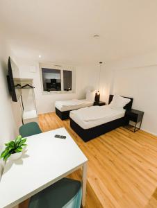 a hotel room with two beds and a table and a room at Montelio Living in Ettlingen