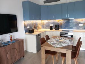 a kitchen with blue cabinets and a table and chairs at Thalassoudis-House 2 in Agios Nikolaos