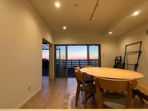 a dining room with a wooden table and chairs at Villa Okubo Akiya in Yokosuka