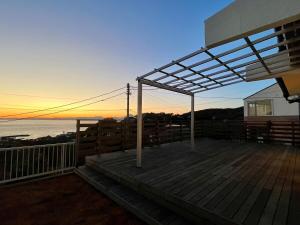 a deck with a view of the ocean at sunset at Villa Okubo Akiya in Yokosuka +34 photos