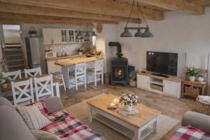 a living room with a fireplace and a table and a kitchen at Chata pod kopcom in Žarnovica