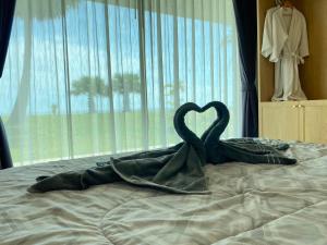 a pair of swans forming a heart on a bed at F&F Poolvilla Beach Tha Chana in Suratthani