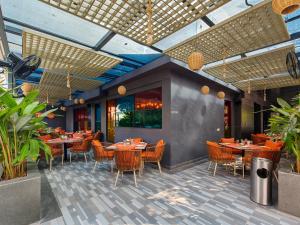 a dining room with tables and chairs in a restaurant at Ira by Orchid Hyderabad Hitech City Mindspace IT Park in Hyderabad