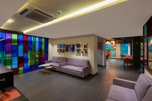 a lobby with a couch and stained glass windows at Ira by Orchid Hyderabad Hitech City Mindspace IT Park in Hyderabad