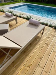 a pool deck with two benches next to a swimming pool at Corte San Martino in La Morra