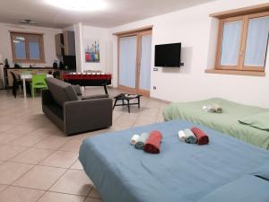 a living room with two beds and a couch and a table at Appartamento da Nonna Anna in Montagna in Valtellina